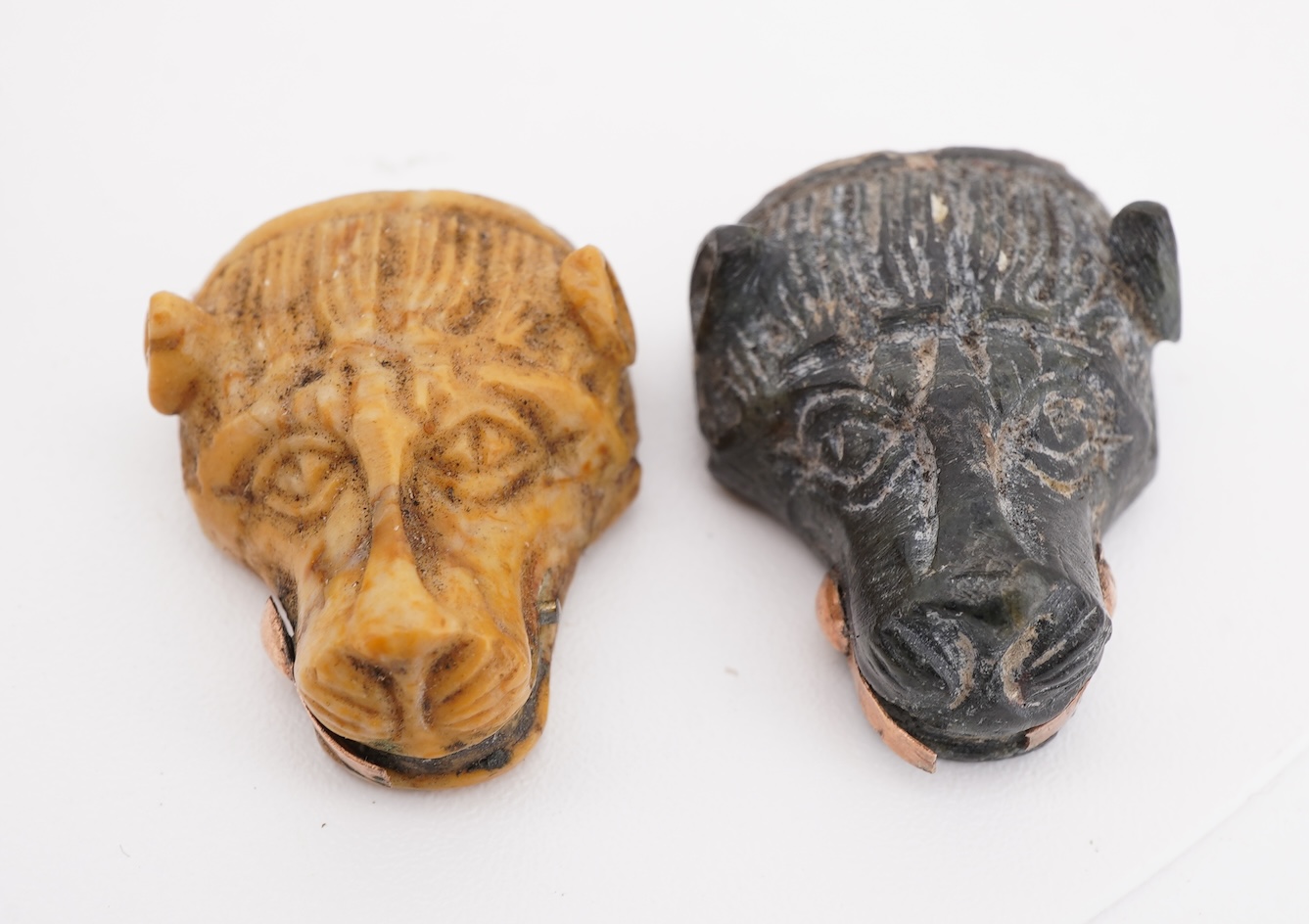 A collection of carved lava fragments, 19th century, once forming a bangle, the fragments variously carved with abstract floral motifs, lion's heads, and a theatrical mask, largest 6.2cm, Condition: fragmentary, but carv